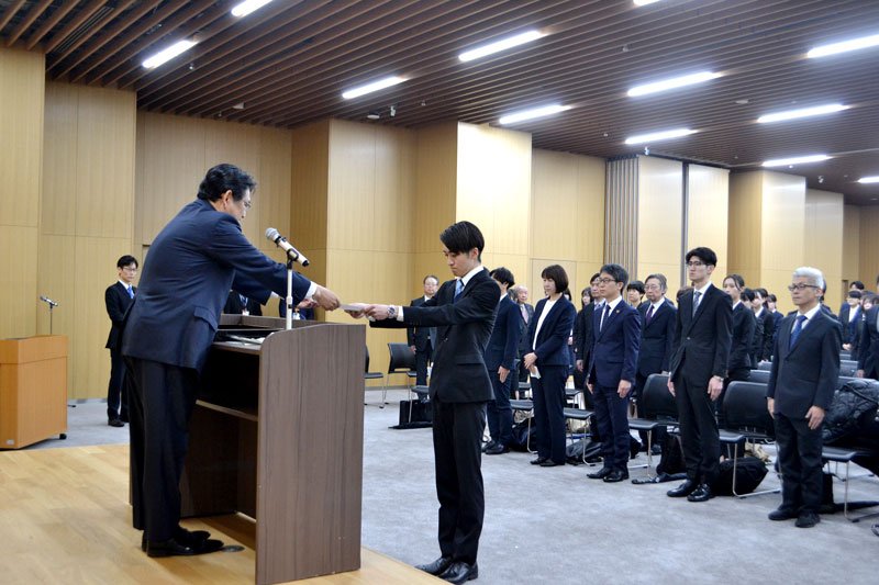 神谷市長（左）から辞令を受け取る新規採用職員ら＝１日、千葉市役所