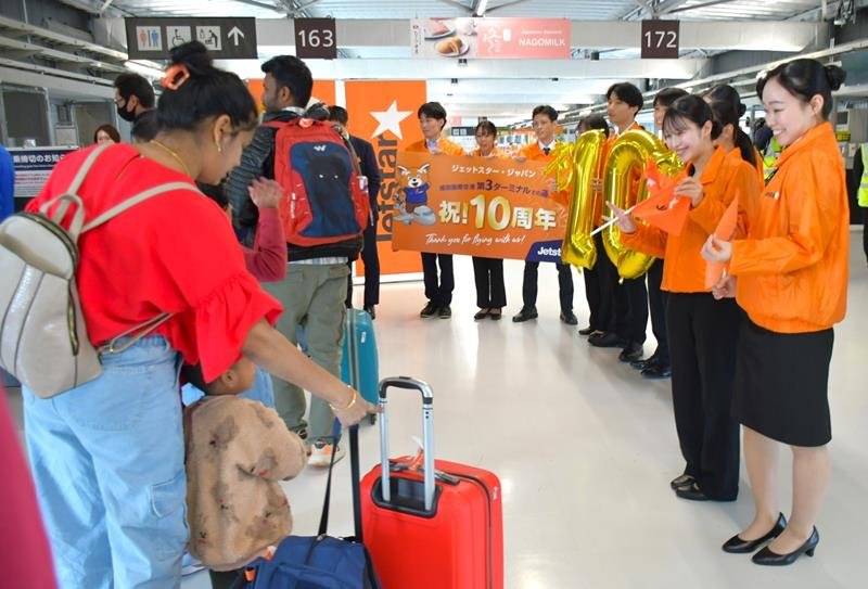 成田空港第３ターミナル開業１０年を記念し、搭乗ゲートで旅客を見送るジェットスター・ジャパンの新入社員ら＝７日、成田市
