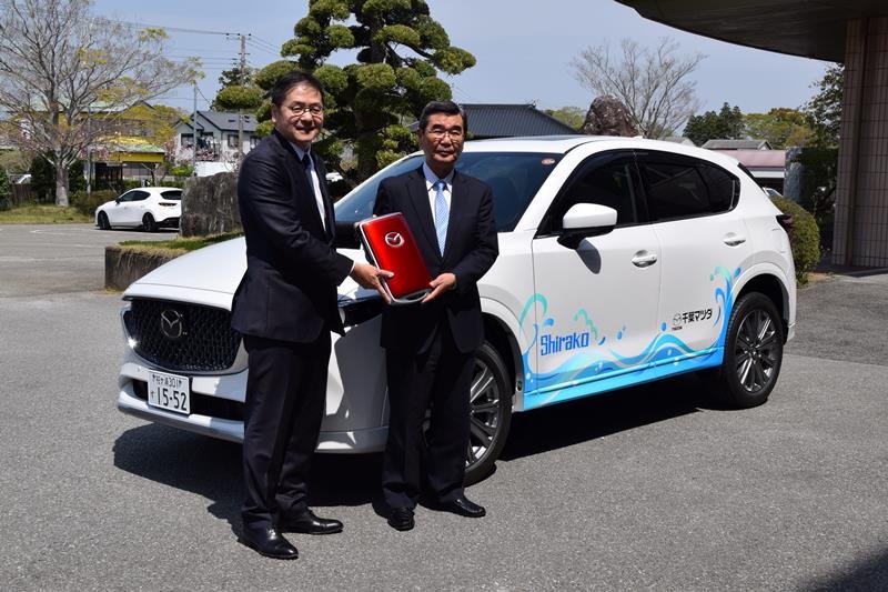 ＳＵＶ車のセレモニーキーを、石井町長（右）に手渡す大木社長＝白子町

