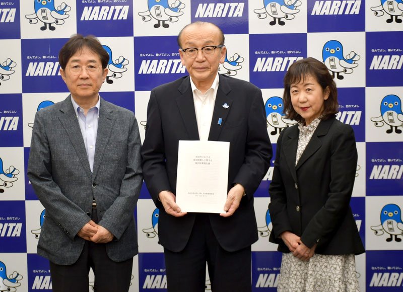 成田市の小泉市長（中央）に市独自の宿泊税導入に関する検討結果報告書を提出した有識者懇談会の星野会長（左）と千葉経済大短期大学部教授の影山美佐子副会長＝２８日、同市役所