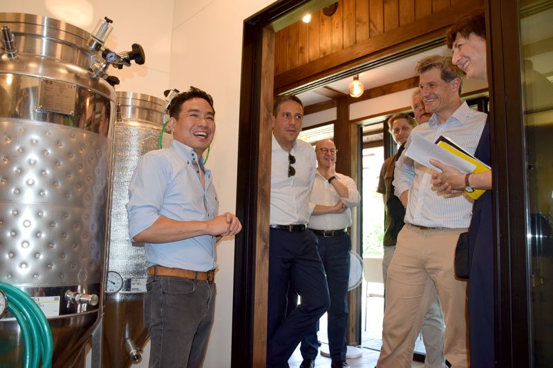 デュッセルドルフ市のツァウム副市長（右から２人目）に醸造所を説明する井上さん（左）＝長柄町