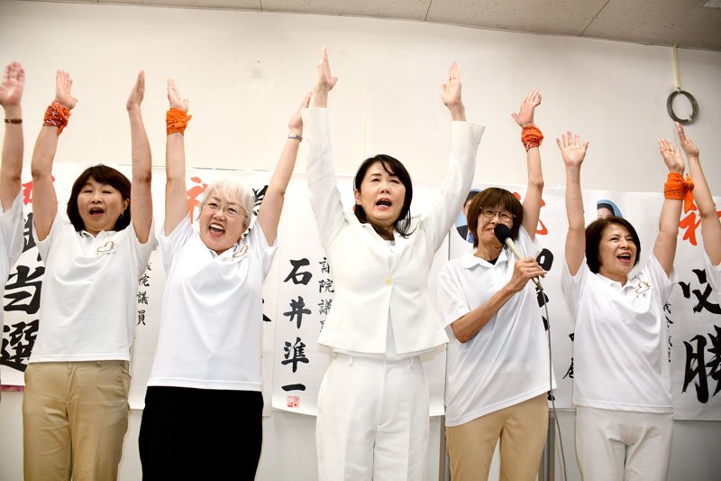 万歳三唱して当選を喜ぶ芝田氏（中央）＝２２日夜、鎌ケ谷市