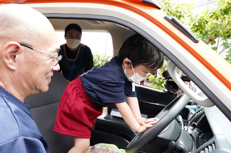 両手を使って送迎バスのクラクションを鳴らす園児＝銚子市
