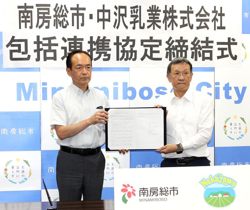 協定書を見せる石井市長（左）と中沢乳業の中沢社長＝南房総市