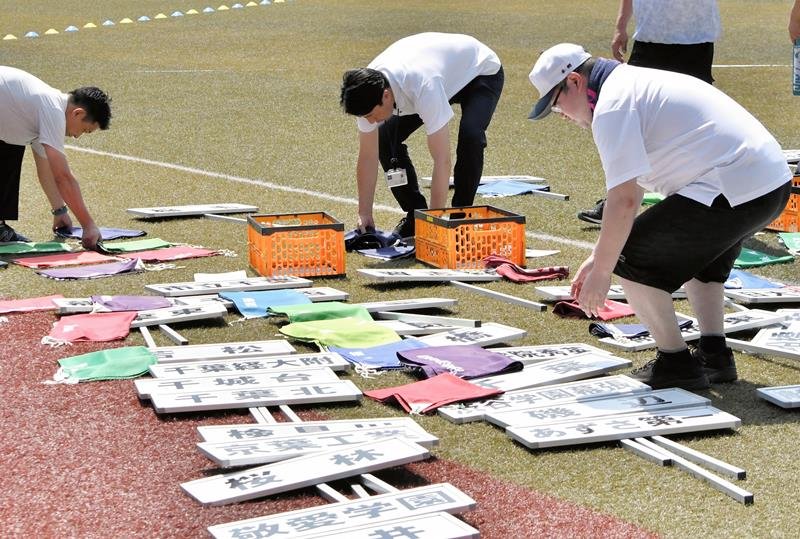 開会式の準備でプラカードを並べる関係者＝４日、千葉市美浜区のＺＯＺＯマリンスタジアム
