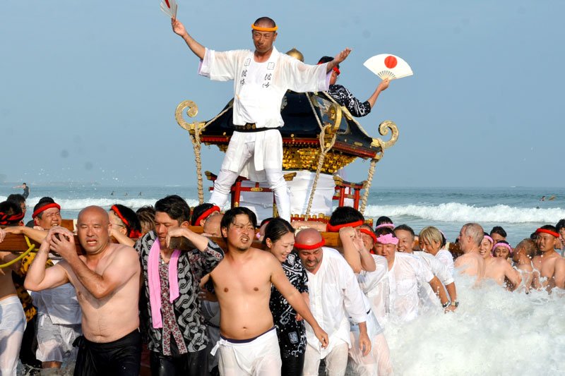 伝統の「汐ふみ」。神輿の担ぎ手たちは海に漬かったり、波打ち際で水しぶきを浴びながら勇ましく走ったりした＝５日夕、御宿町