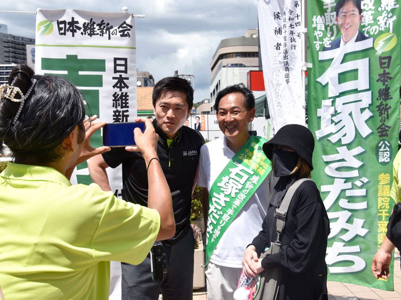 演説後に吉村氏（左）とともに写真撮影に応じる石塚氏＝１０日、松戸駅前
