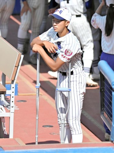 試合開始前に松葉杖をつきグラウンドを見つめる敬愛学園・臼杵
