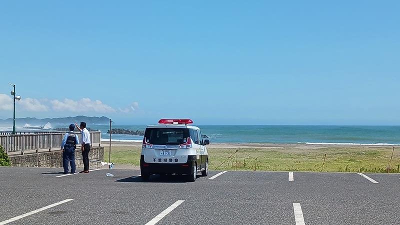 津波警報が発令されたため海水浴場で避難を呼びかける警察官＝３０日午前、いすみ市
