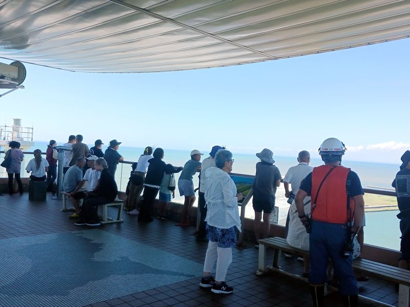 津波警報発令中の海の様子を、高台にある飯岡刑部岬展望館から眺める避難者＝３０日午前、旭市