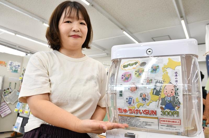 伊能忠敬がモチーフの「ちゅうけいＳＵＮガチャ」を紹介する水郷佐原観光協会の職員＝香取市
