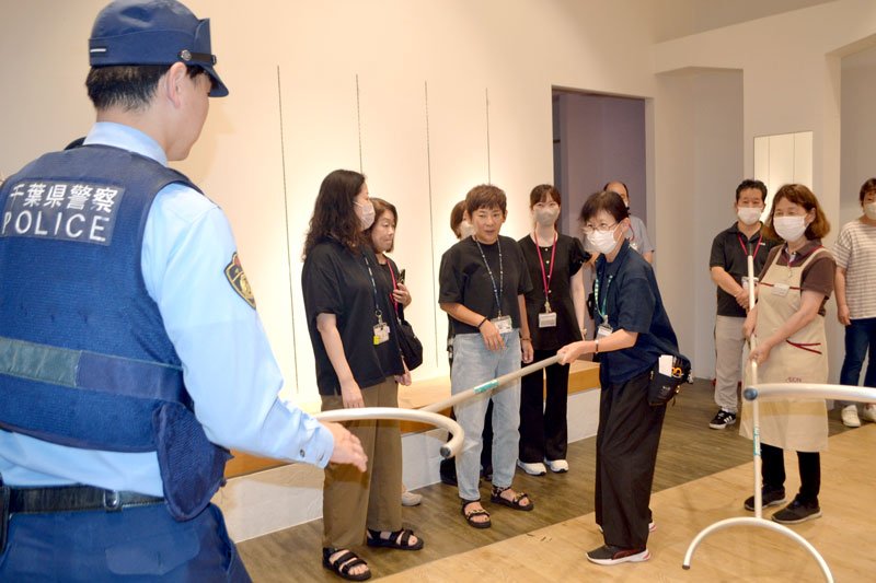 警察官にアドバイスを受けながらさすまたの使い方を確認する従業員ら＝印西市のイオンモール千葉ニュータウン