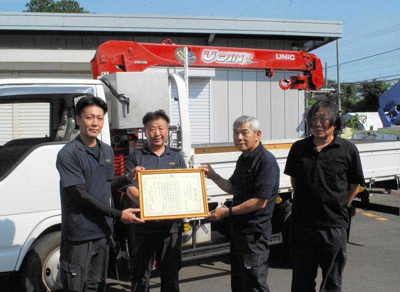 感謝状を贈られた（左から）花村竜太さん、河野直樹さん、黒田一夫さん、横山善弘さんと、救出時に使ったユニック車＝２１日、千葉市緑区越智町の「ＣＰＳ機電」