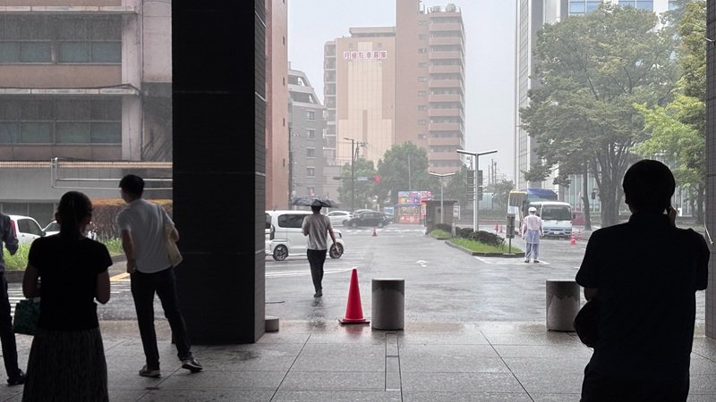 激しい雨が弱まるのを待つ人たち＝12日午後0時55分ごろ、千葉市中央区