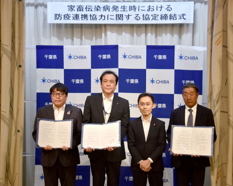 家畜伝染病発生時の防疫連携協力に関する協定書を交わした黒野副知事（中央右）と民間事業者３社の出席者＝千葉県庁