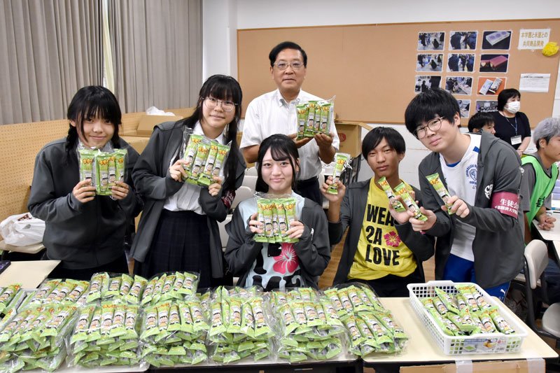 「まずい棒　メロンパン風味」をＰＲする竹本社長（奥）と生徒会のメンバー＝千葉市稲毛区
