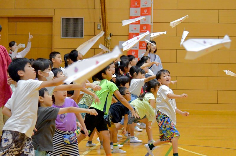 丁寧に折った紙飛行機を勢いよく飛ばす児童ら＝成田市