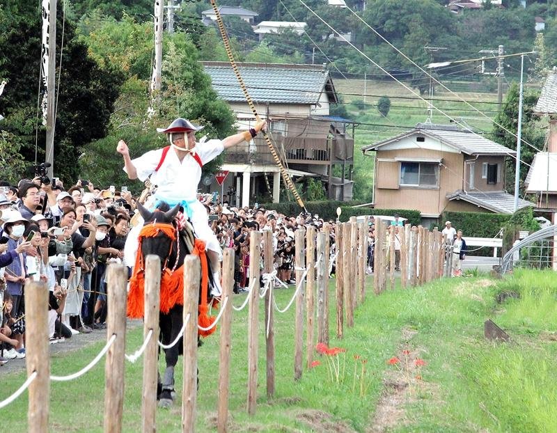 馬上から的を狙って矢を放つ禰宜＝２８日、鴨川市