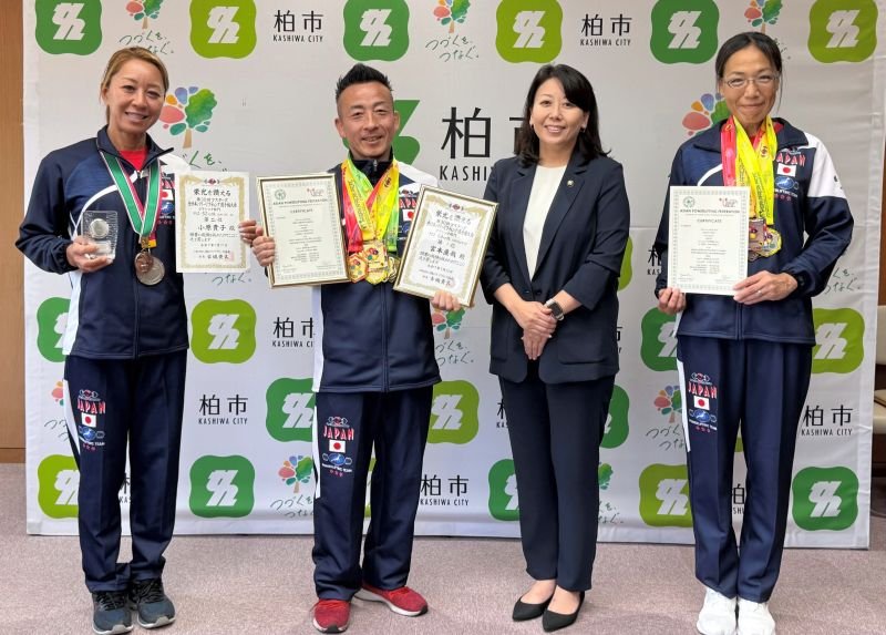 太田市長（右から２人目）に快挙を報告した宮本代表（同３人目）、佐藤選手（右）、小原選手＝柏市
