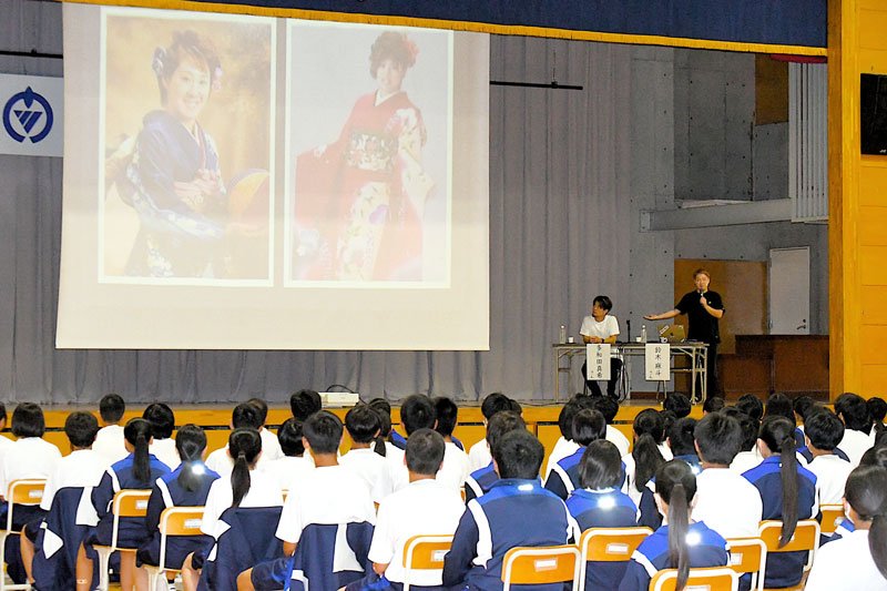 「多様な人生の歩き方」をテーマに講演する鈴木さん（右奥）と多和田さん。２人の成人式の写真を紹介した＝勝浦市