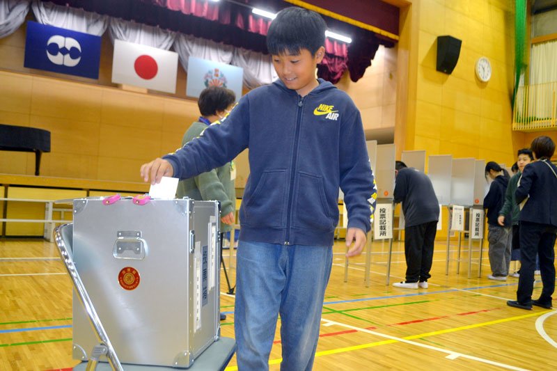 本番さながらの環境で模擬投票を行う子どもたち＝八街市立朝陽小学校