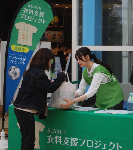 不用品を届けに来た女性（左）とそれを受け取るプロジェクトのスタッフ＝８日、柏市の「ららぽーと柏の葉」
