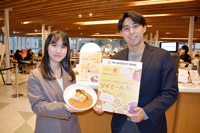学生食堂で「ソイミールカレー」をＰＲする「ＴＨＥ　ＵＤ・プロジェクト」の横倉さん（右）と黒須さん＝千葉商科大学
