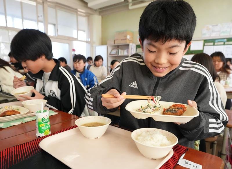 自身が考案した赤ピーマンのサラダを食べる野中君（右）＝匝瑳市立野田小
