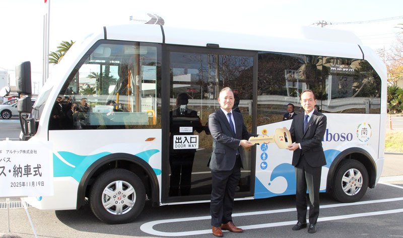 ＥＶバス納車式でアルテックの奥田哲太郎取締役（左）からレプリカキーを受け取る石井市長＝南房総市役所