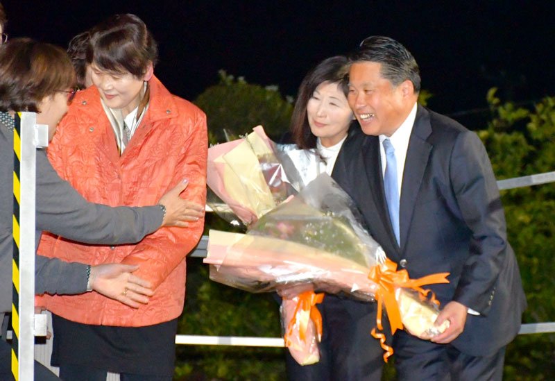 再選を決めて支持者から花束を贈られる麻生氏（右）＝３０日午後９時５０分ごろ、芝山町
