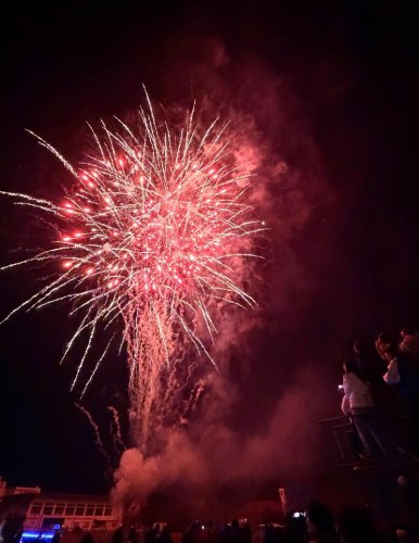 人生の新たなスタートを祝って打ち上げられた赤い花火＝５日夜、富津市

