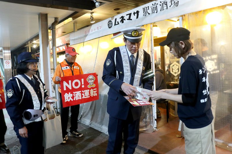 酒を提供する飲食店に飲酒運転防止の協力を呼びかける市原署員ら＝１７日夜、市原市