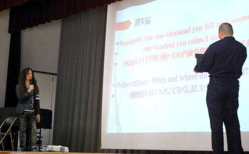 流山署の指定通訳員（右）と「遺失届」の実演をするマーティ・フリードマンさん＝１１日、流山市の八木中学校