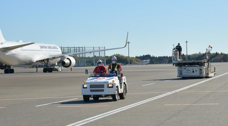 成田空港の駐機場で航空機近くの道路を走行するけん引車両など特殊車両＝12月、成田市（記事と直接関係ありません）