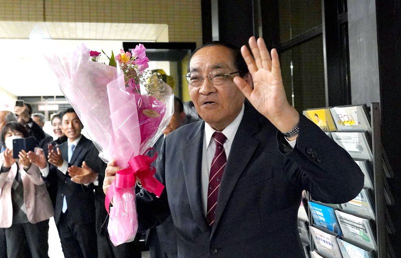 花束を手に笑顔を見せる太田氏＝２４日、いすみ市役所
