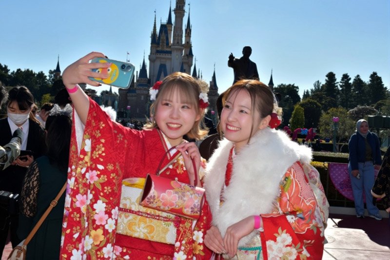 仲良く記念撮影する「新２０歳」たち。背後に見えるのがシンデレラ城＝浦安市の東京ディズニーランド