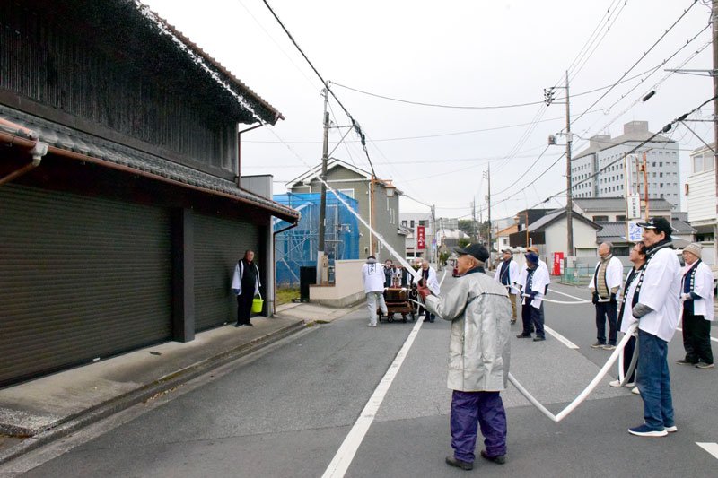 火事のない１年を願い家屋に放水する住民＝１１日、茂原市