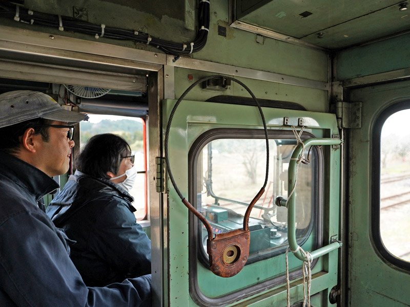 いすみ鉄道運転士の指導を受けながら車両の運転を体験する参加者（右）＝いすみ市