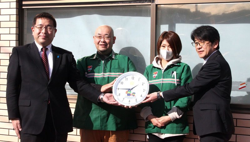 鴨川署の山口健司署長（左）から贈呈された時計を見せる山口幸一さん（左から２人目）＝鴨川市