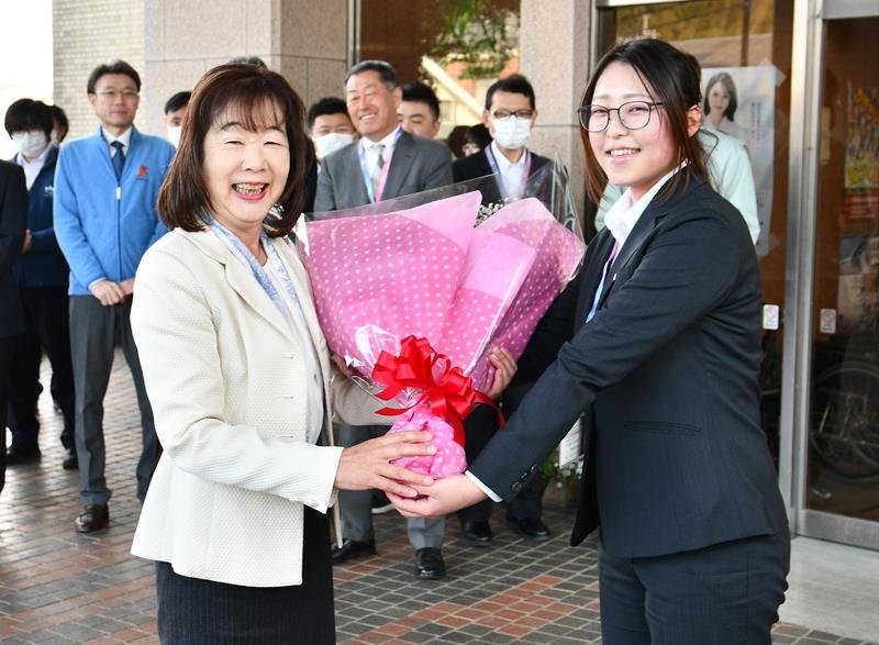 ２期目の初登庁で町職員から花束を受け取る平山町長（左）＝６日、多古町
