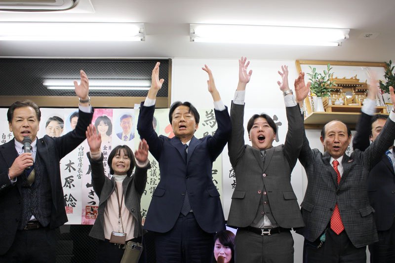 当選確実となり、支援者らと万歳する自民党の門山氏（中央）＝８日、千葉市中央区