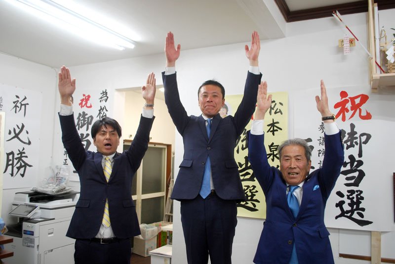 初当選を決め、万歳する自民党の松本氏（中央）＝９日、柏市