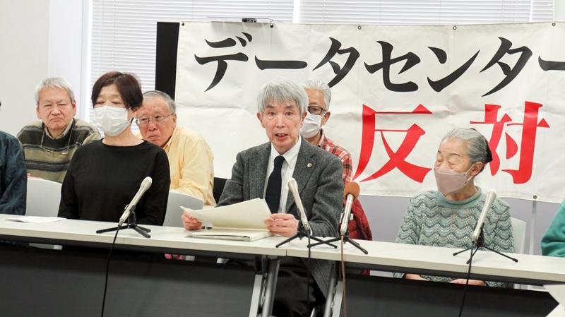 記者会見で訴えを主張する原告の及川弁護士（前列中央）とＤＣの近隣住民ら＝２７日、千葉市中央区の県弁護士会館