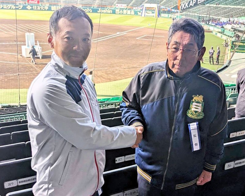 初戦に向けた対談で握手を交わす専大松戸の持丸監督（右）と北照の上林監督＝甲子園