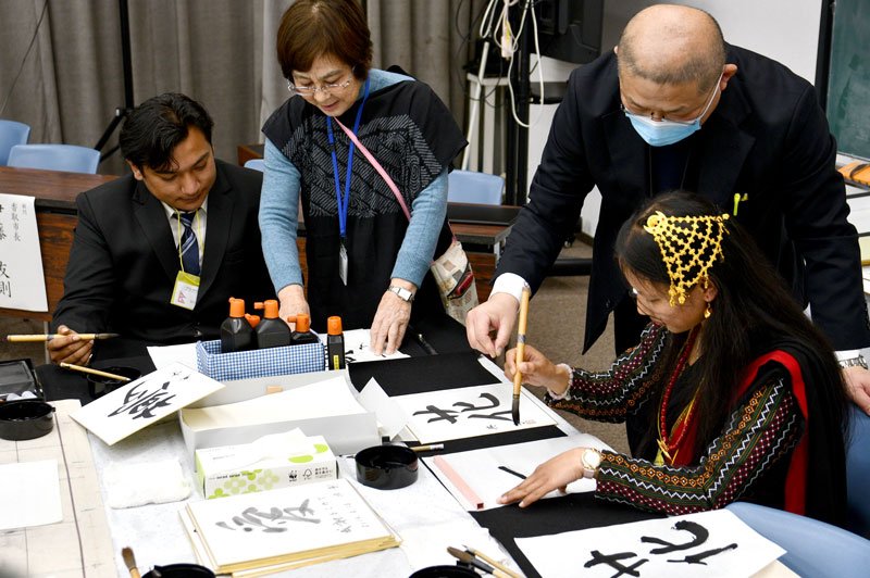 担当者に教わりながら書道に挑戦する外国人＝香取市
