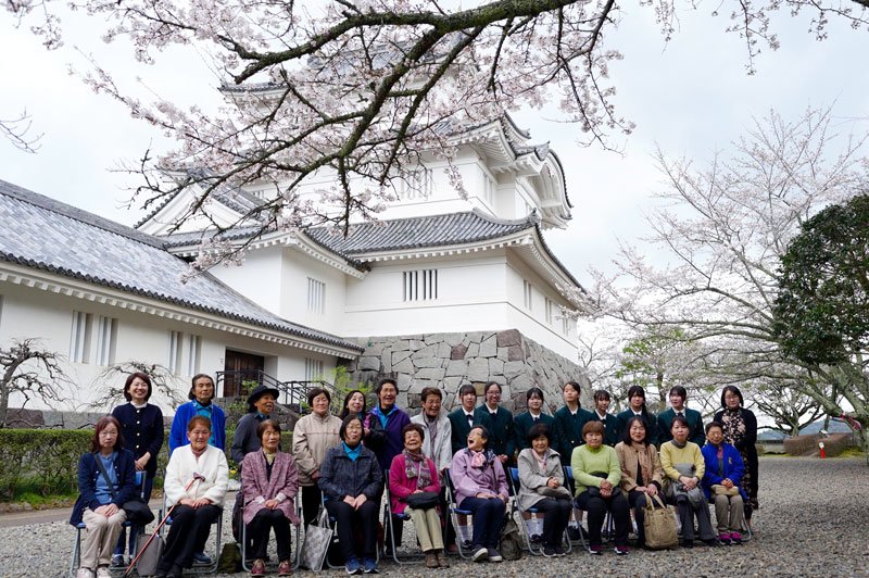 記念の集合写真を撮影する「大多喜城と桜を楽しむ会」の参加者や地元高校生＝２７日、大多喜町