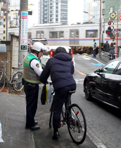 自転車交通違反への反則金「青切符」制度導入の初日、違反者に指導・警告をする警察官。従わなかったり、危険を招いたりする違反が青切符通告の対象＝１日午前８時４０分ごろ、市川市