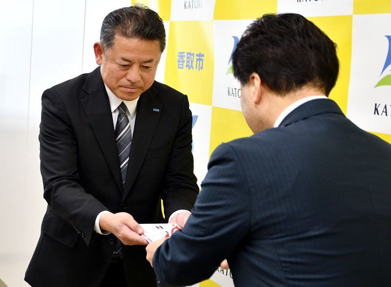 伊藤市長（手前）に目録を手渡す中川所長＝香取市
