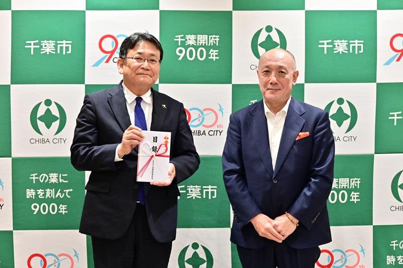 木下勝義事務局長（右）から神谷俊一市長に目録が手渡された＝８日、千葉市役所
