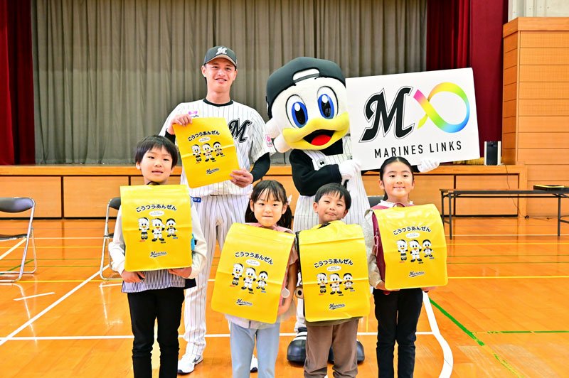 新小学１年生にランドセルカバーを贈った毛利選手（後列左）＝２１日、千葉市美浜区